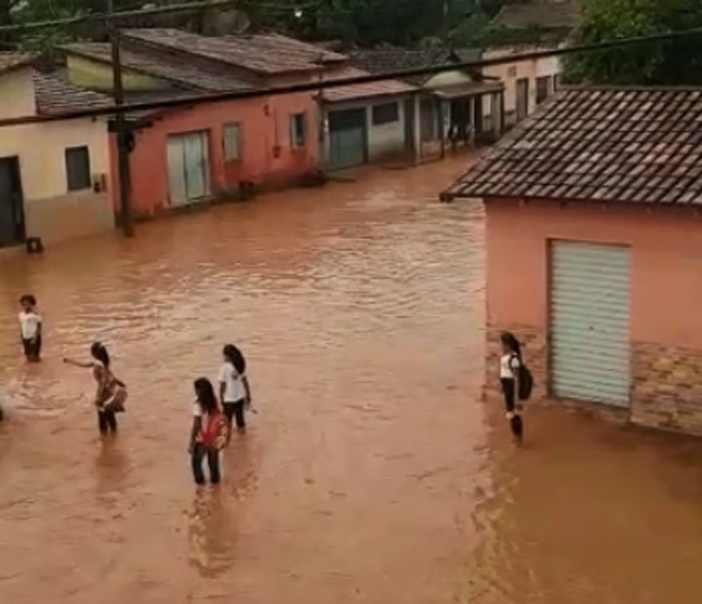 Ruas de Itabela ficam alagadas e estudantes andam pela água para deixar unidades de ensino  — Foto: Reprodução/TV Bahia