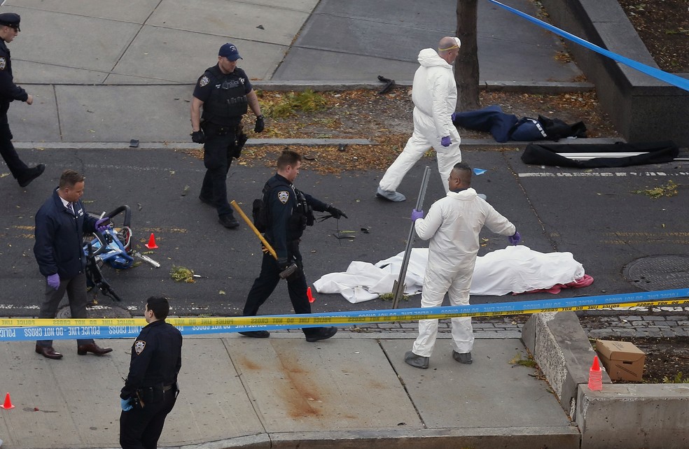 Autoridades investigam a cena perto de corpo coberto, em Nova York  (Foto: Bebeto Matthews/AP)