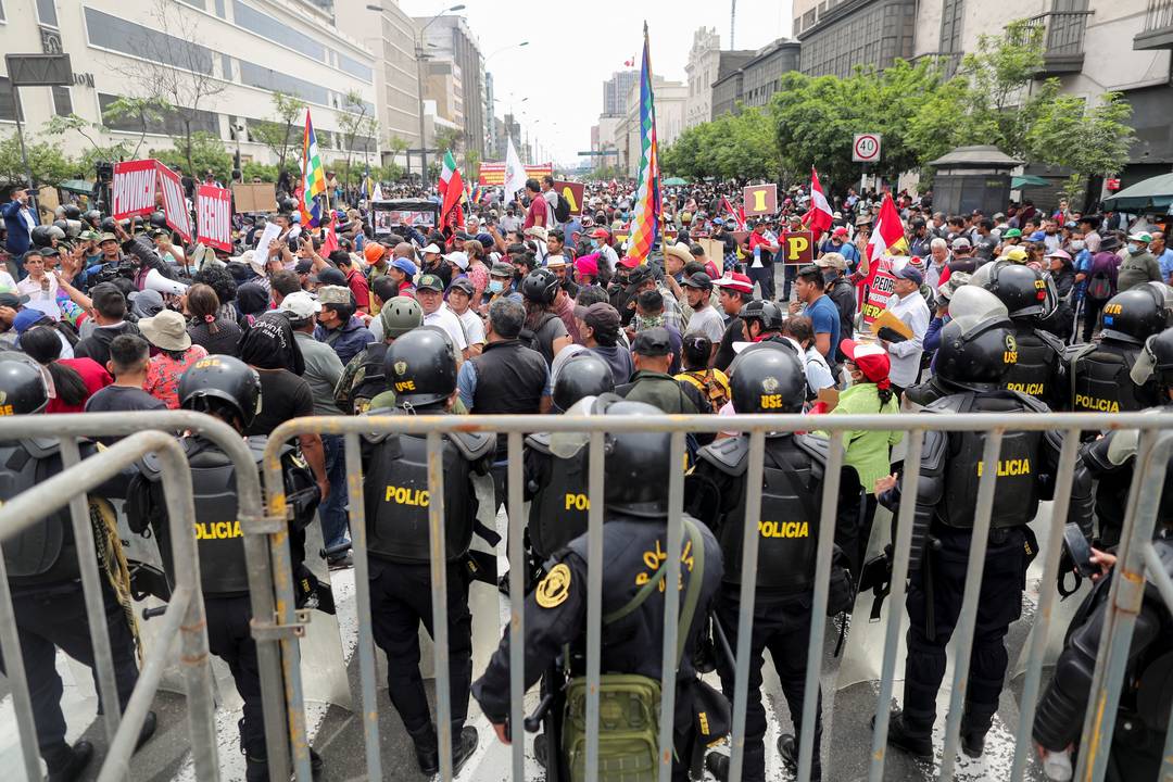 Policiais do Peru se posicionam na frente do Congresso nacional enquanto populares se manifestam