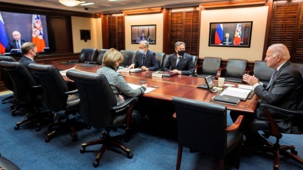 Biden (à direita) disse estar confiante de que Putin (à esquerda no monitor) recebeu sua mensagem — Foto: Reuters/BBC