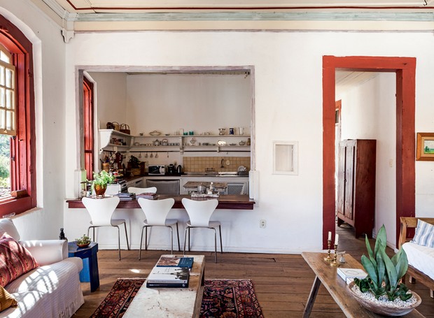 Sala de jantar | A bancada de madeira, que faz as vezes de sala de jantar, une a cozinha e o estar. Cadeiras e mesa lateral da galeria Nino Nogueira (Foto: Lufe Gomes)