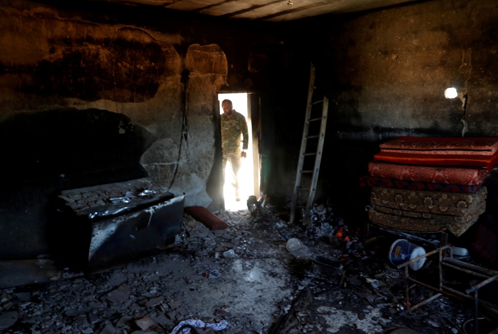 Integrante da ONU observa uma sala queimada durante os confrontos na Líbia — Foto: Goran Tomasevic/Reuters