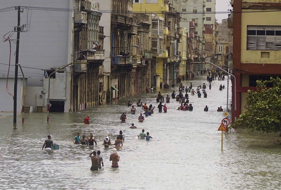 Pessoas atravessam ruas inundadas em Havana após a passagem do furacão Irma, em Cuba (Foto: Ramon Espinosa/AP)