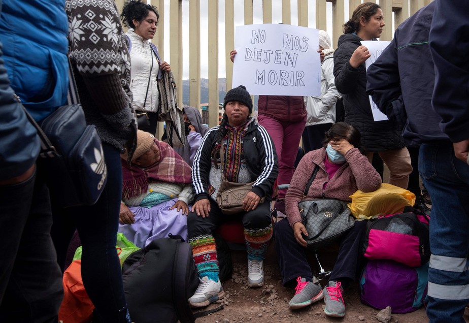 Passageiros sentam-se do lado de fora da entrada do Aeroporto Internacional Alejandro Velasco Astete, em Cusco, que foi fechado