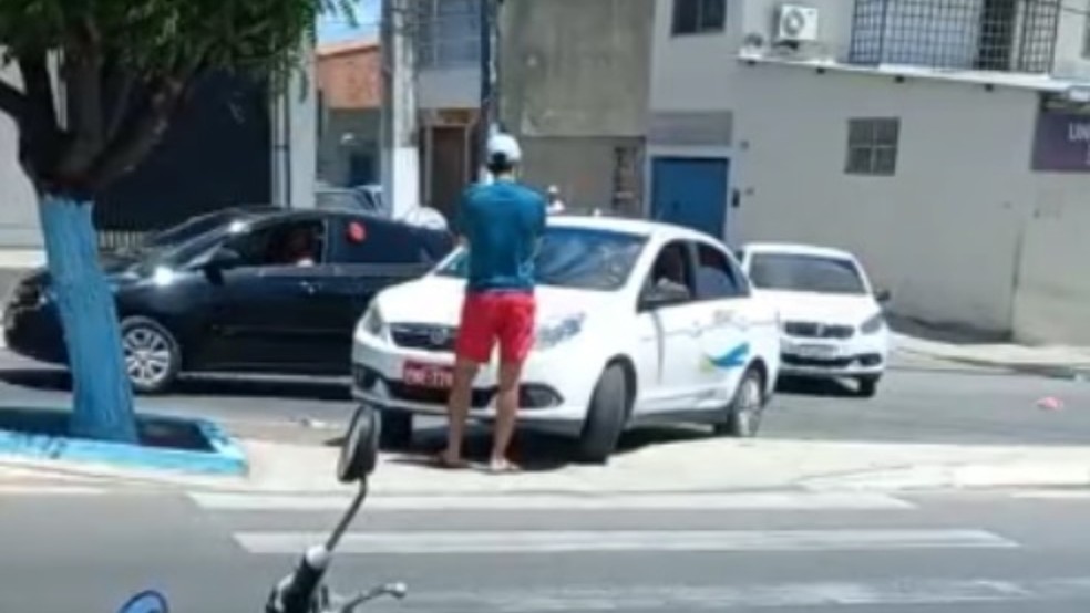Pedestre bloqueia taxista e impede que veículo trafegue sobre canteiro central em avenida em Caucaia, na Grande Fortaleza — Foto: TV Verdes Mares/Reprodução