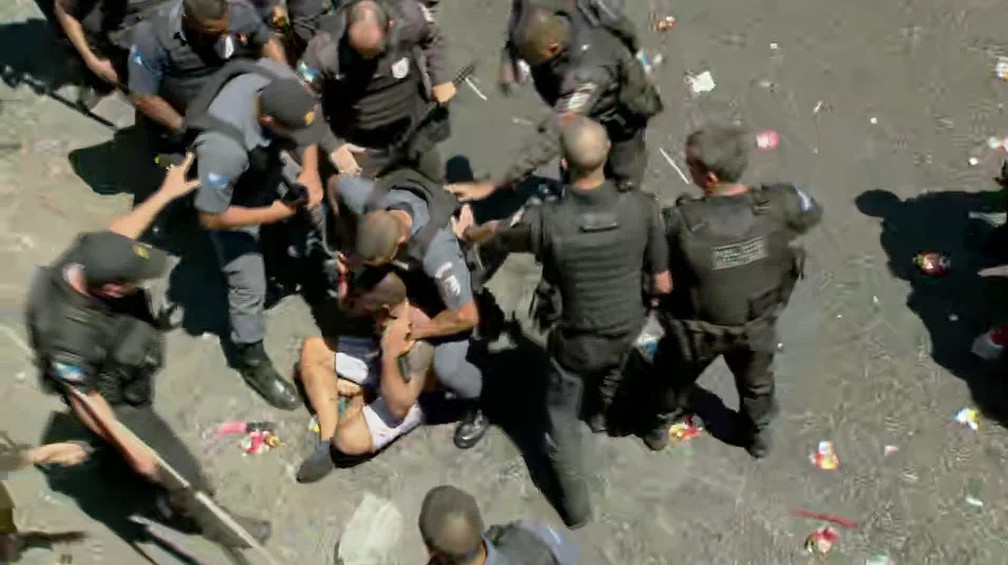 Homem é imobilizado por policiais durante o bloco Fervo da Lud, no Rio — Foto: Reprodução/GloboNes