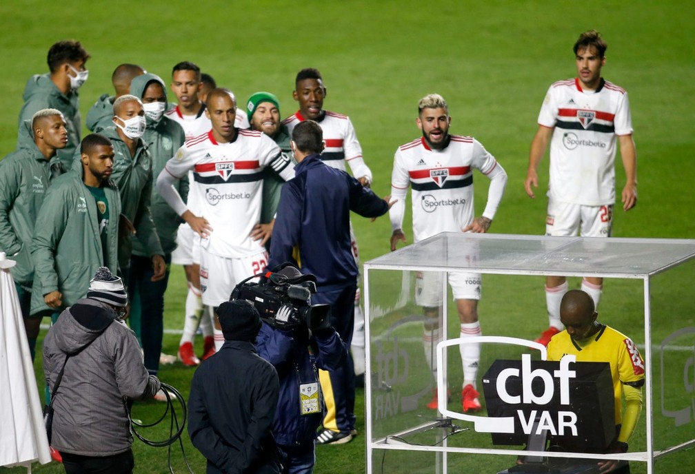 Jogadores do São Paulo e do Palmeiras observam o árbitro analisar lance de gol no VAR — Foto: Marcos Ribolli