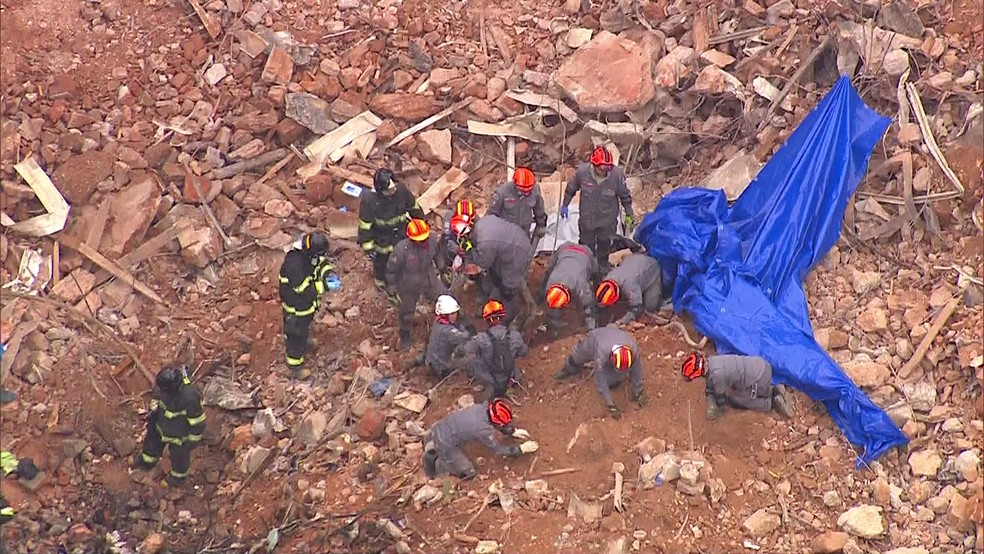 Bombeiros fazem escavação manual após identificarem corpo em escombros (Foto: Reprodução/TV Globo)