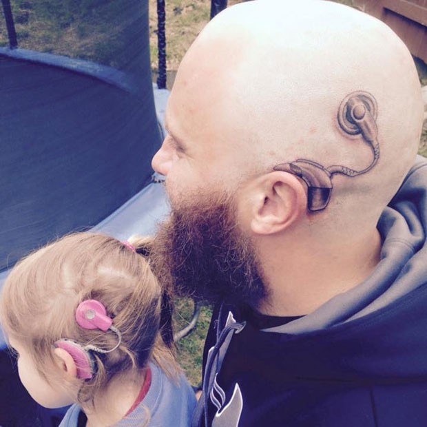 Alistair Campbell com sua tatuagem e a filha Charlotte, de 6 anos, com o aparelho de audição, em foto postada pela mãe (Foto: Reprodução / Facebook)