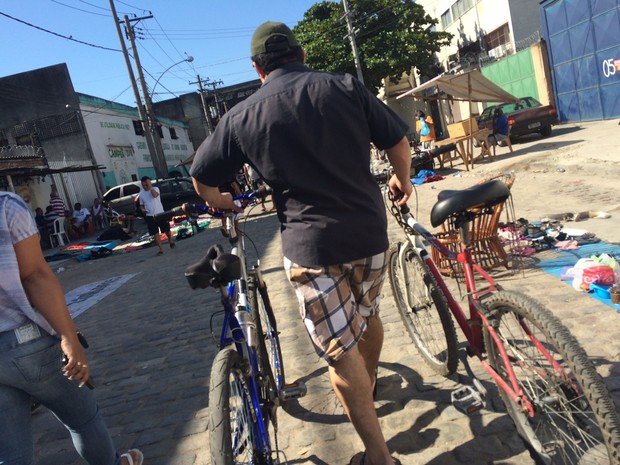 Homem circula em feira negociando duas bicicletas (Foto: Matheus Rodrigues/ G1)
