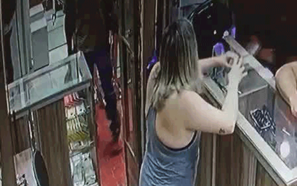 Vendedora e cliente de loja de celulares são surpreendidos por ladrão armado na Feira dos Importados, no DF (Foto: TV Globo/Reprodução)