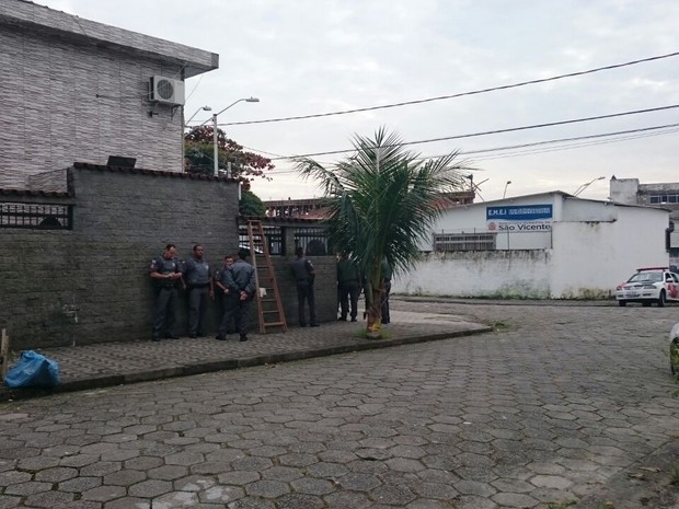 Policiais cercam casa próximo à escola de São Vicente (Foto: Guilherme Lucio / G1)