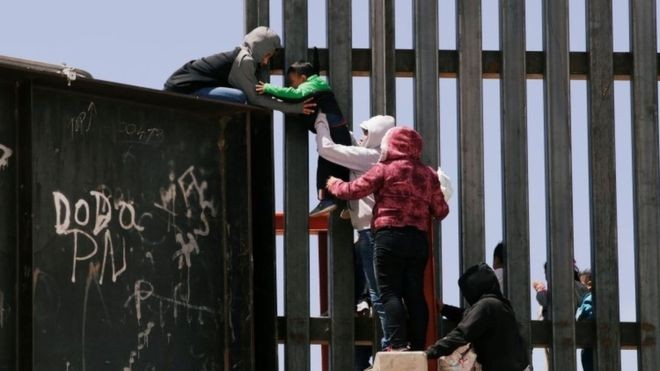 Criança sendo levada pela fronteira; número de migrantes detidos está no maior nível desde 2006, mas mesmo assim está distante do pico dos anos 2000 (Foto: Reuters, via BBC)