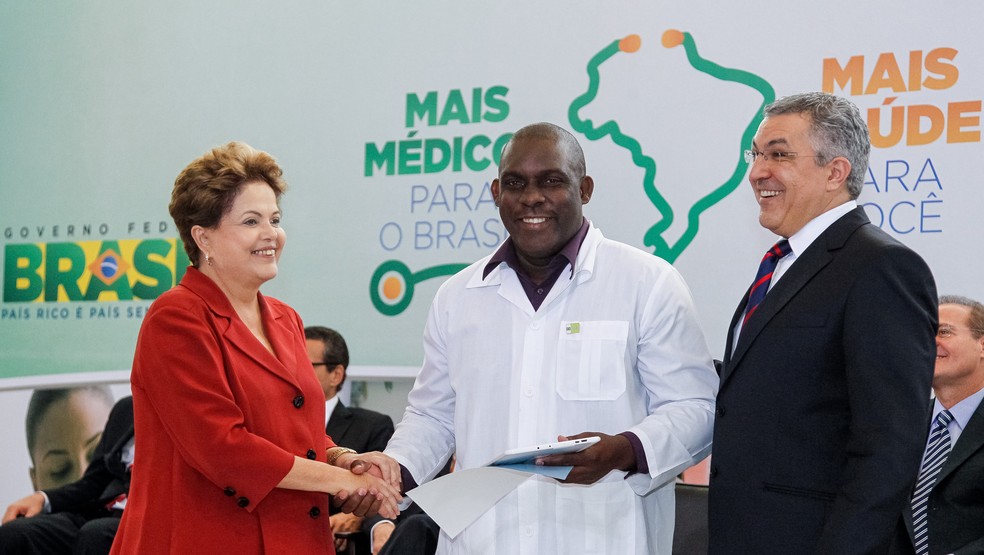 Presidente Dilma Rousseff, o médico cubano Juan Delgado e o Ministro da Saúde Alexandre Padilha durante sanção da lei que institui o Programa Mais Médicos.  — Foto: Roberto Stuckert Filho/PR