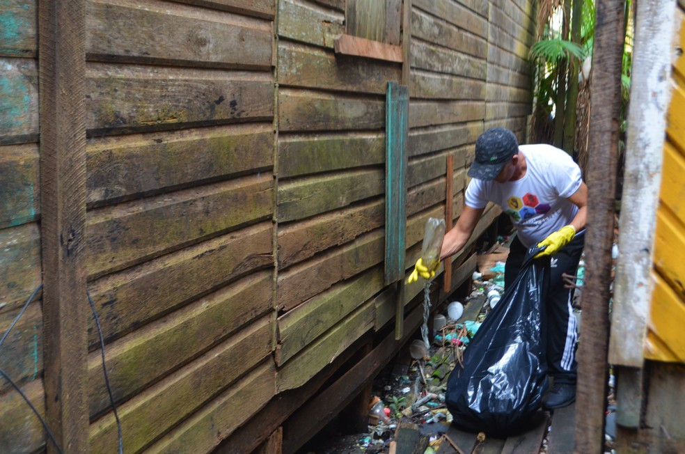 VoluntÃ¡rios limpam lixo no entorno de casas em Santana â Foto: Carlos Alberto Jr/G1