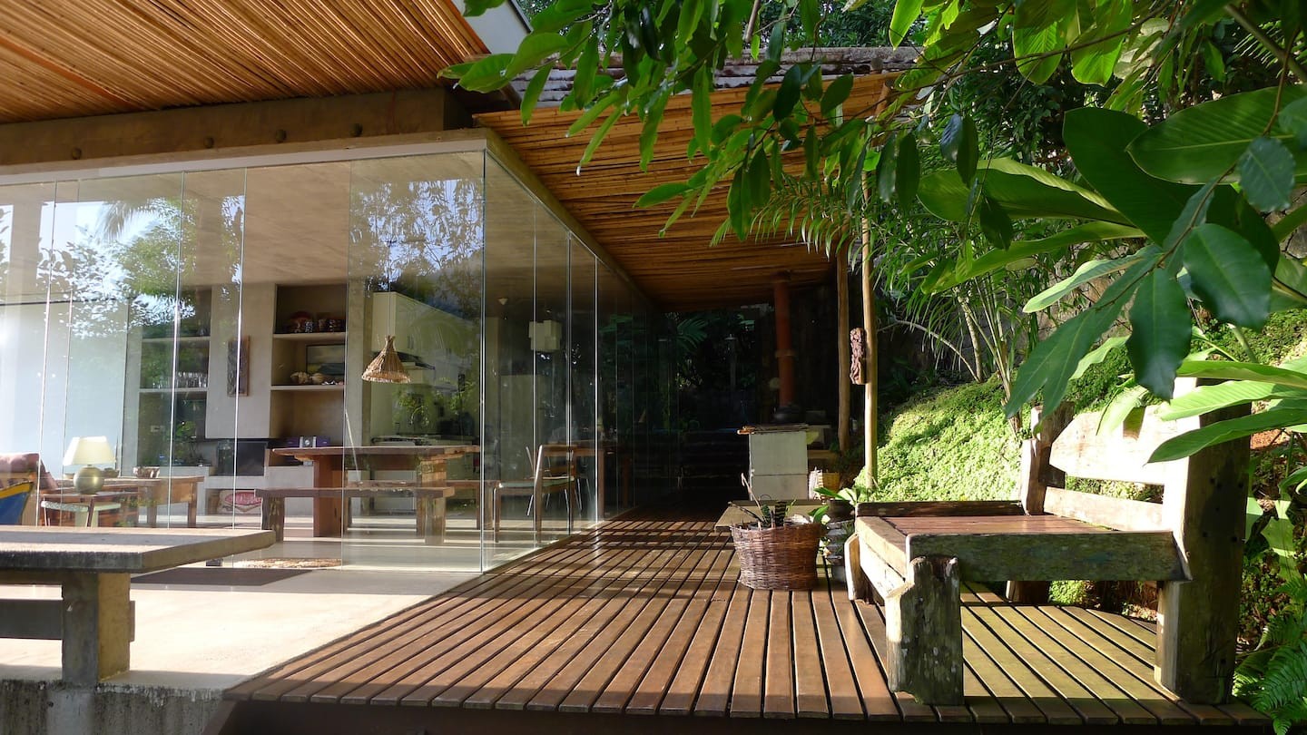 Com fechamento em vidro, a casa permite apreciar a vista da floresta e praia no entorno (Foto: Reprodução / Airbnb)