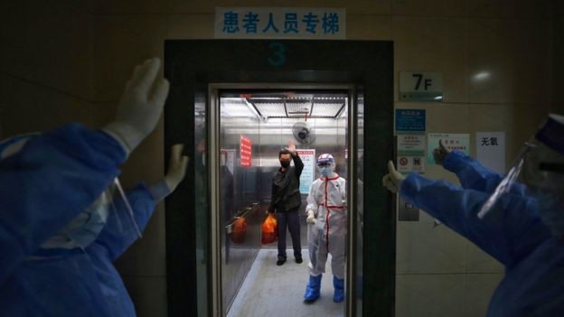 Equipe de hospital em Wuhan, na China, se despede de paciente curado da covid-19 (Foto: STR/AFP VIA GETTY IMAGES)