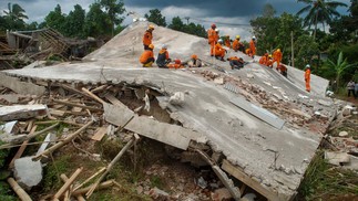 Equipes de resgate procuram vítimas sob as ruínas de edifícios que desabaram em Cianjur após um terremoto que matou mais de 250 pessoas, na Indonésia — Foto: TIMUR MATAHARI / AFP