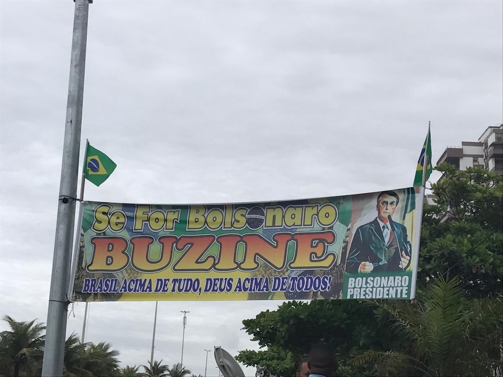 Faixa colocada em frente ao condomínio de Bolsonaro; grande quantidade de motoristas buzina e grita palavras de apoio ao novo presidente — Foto: Patricia Teixeira/G1