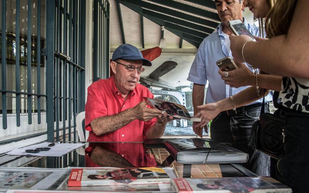 Roberto Escobar conta a turistas a sua versão da verdade e autografa fotos do irmão (Foto: DW/A. Williams)