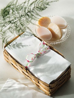 Acomodadas numa cestinha de palha, toalhas de papel substituem as de tecido com muito charme dentro de uma cestinha