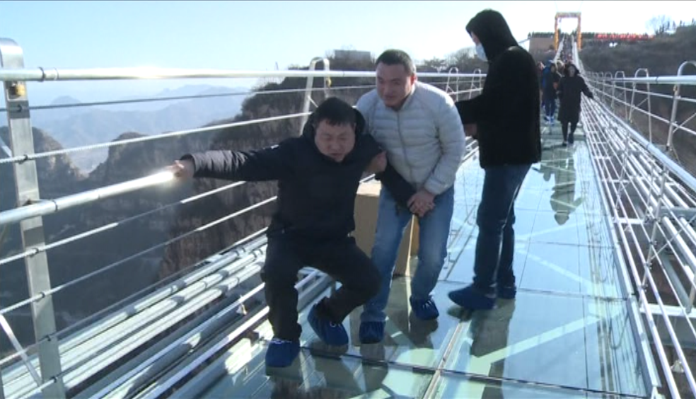 Homem caminha sobre a ponte de vidro mais longa da China (Foto: Reprodução/Reuters)