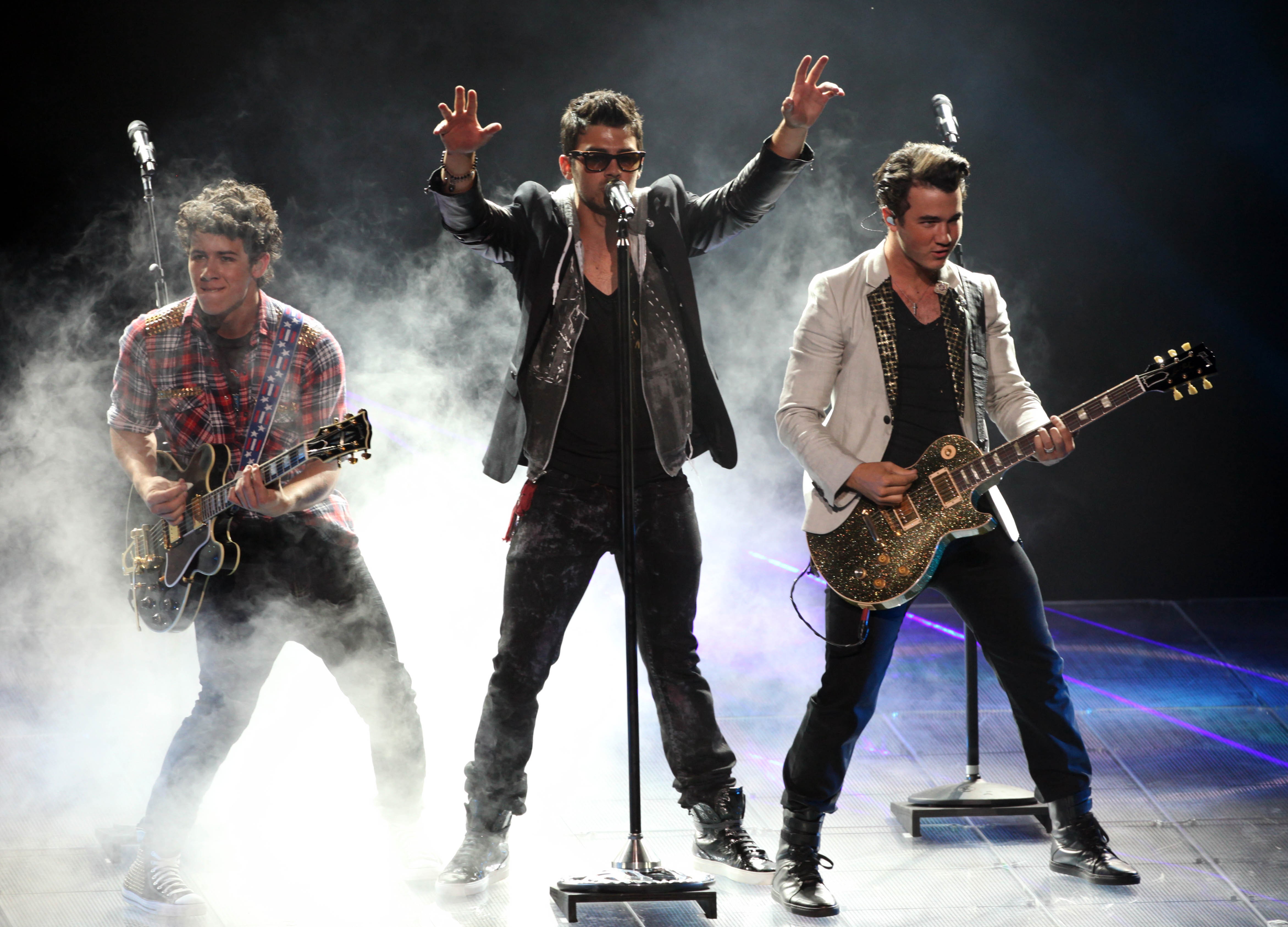 Os três irmãos do grupo Jonas Brothers durante um show (Foto: Getty Images)