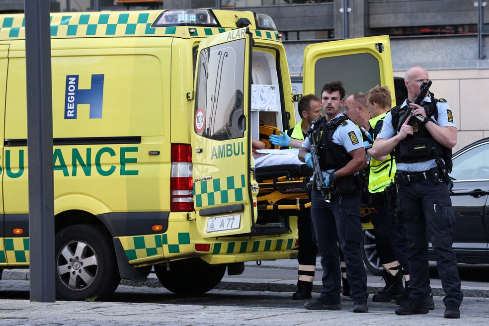 Policiais armados acompanham retirada de sobreviventes do ataque ao shopping Fields, em Copenhague, na Dinamarca, neste domingo (3). &mdash; Foto: Ritzau Scanpix/Olafur Steinar/Reuters