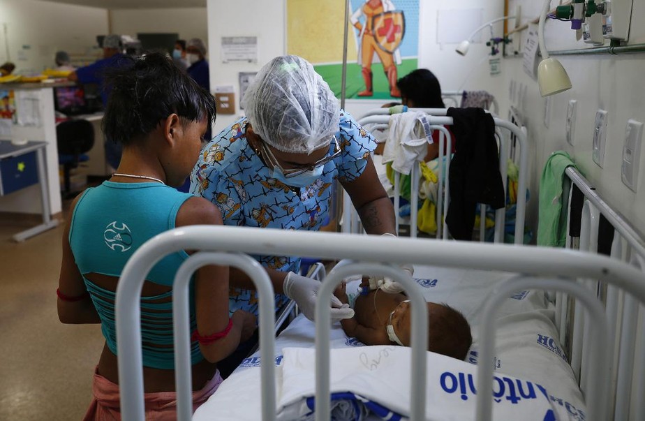 Um bebê yanomami é atendido por uma enfermeira no Hospital Infantil Santo Antonio, em Boa Vista, estado de Roraima