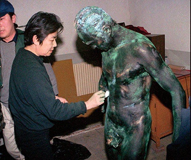 An assistant paints the body of Life Sculpture artist Wang Deshun before a performance in Beijing Tuesday December 10, 1996. Wang, a sixty-year-old former actor, performs almost naked in poses influenced by the sculptures of Rodin. (AP Photo) (Foto: Associated Press)