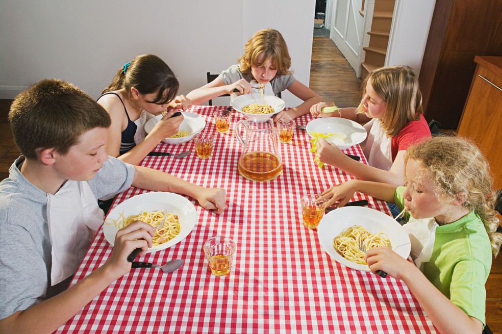 Crianças comendo macarrão (Foto: Frank Herholdt/Image Source)