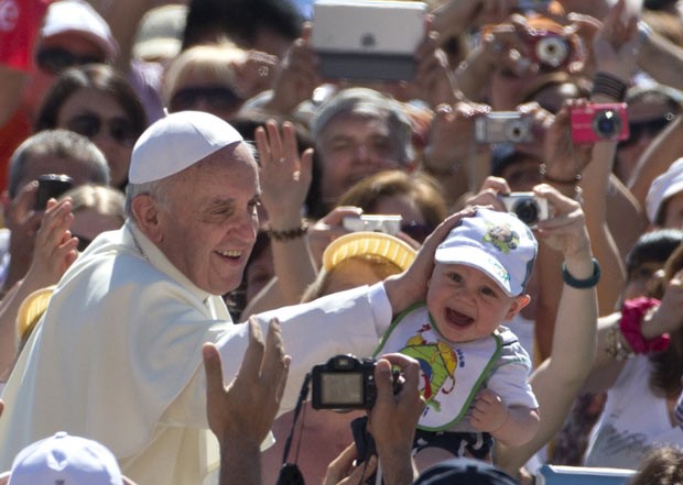 O Papa Francisco brinca com bebê nesta quarta-feira (12) na Praça de São Pedro, no Vaticano (Foto: Alessandra Tarantino/Reuters)