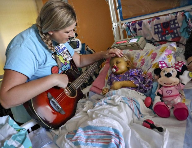 Stephanie tocando para a pequena Elizabeth (Foto: Carl Juste/Miami Herald/TNS)