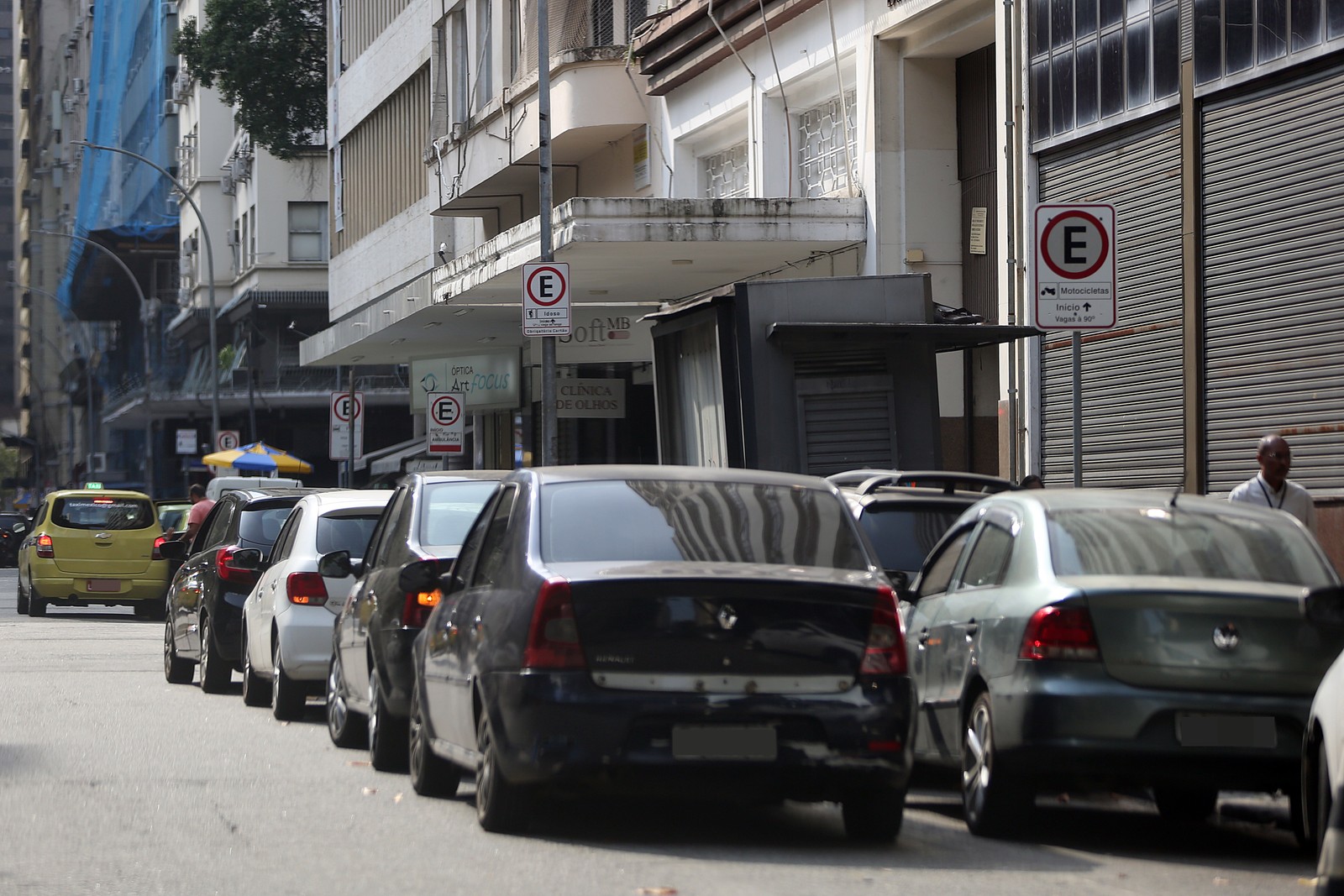 Além da multiplicação das baias cedidas a órgãos públicos, mesmo com placas de proibido estacionar, vagas são ocupadas em trecho da Rua do México  — Foto: Lucas Tavares