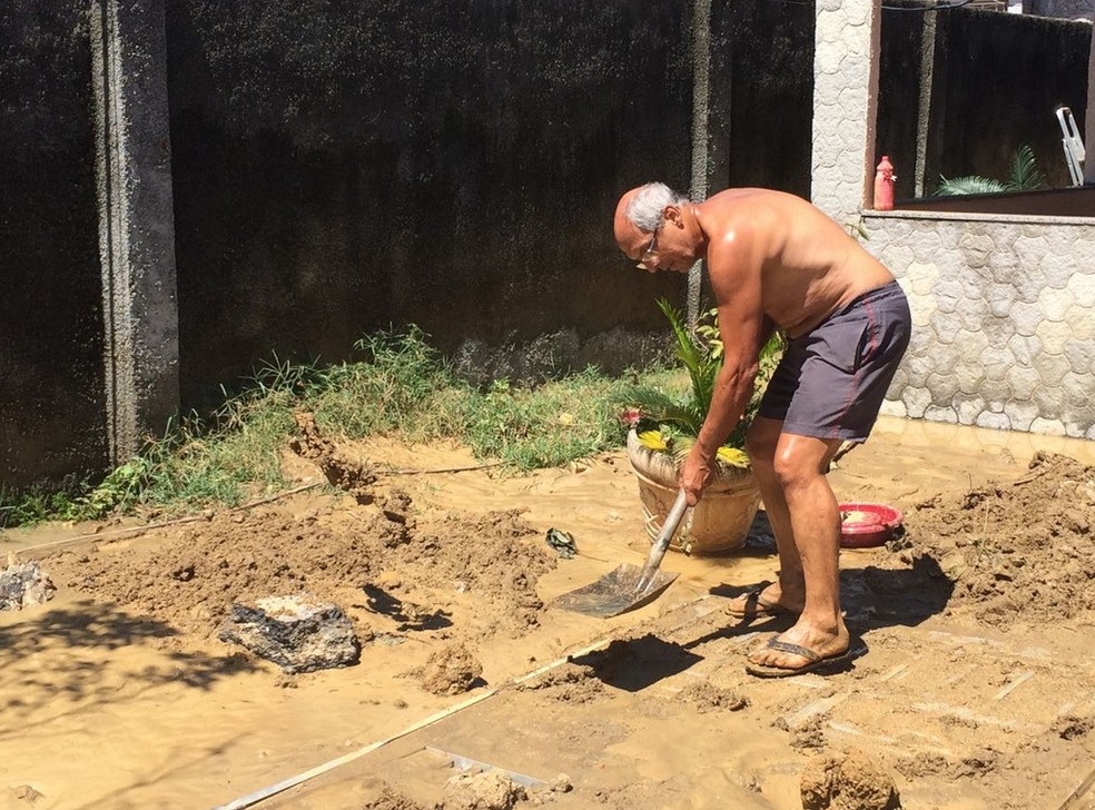 Após rompimento, moradores começaram limpar quintal das casas alagadas (Foto: Matheus Rodrigues/G1)