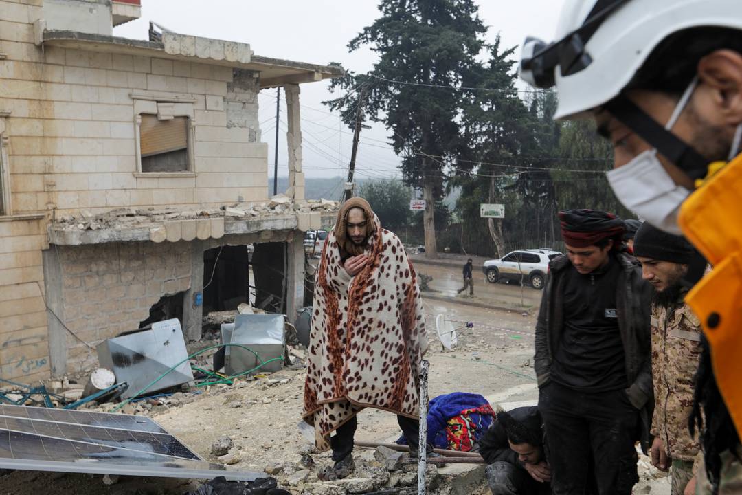 Sobrevivente do terremoto que atingiu a Síria e a Turquia em 6 de fevereiro de 2023 se abriga com cobertor.