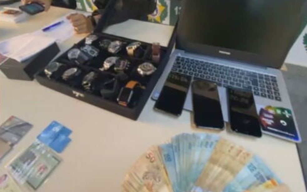 Dinheiro, relógios, computadores e celulares apreendidos com casal suspeito de vender falga vaga de medicina, Goiás — Foto: TV Globo