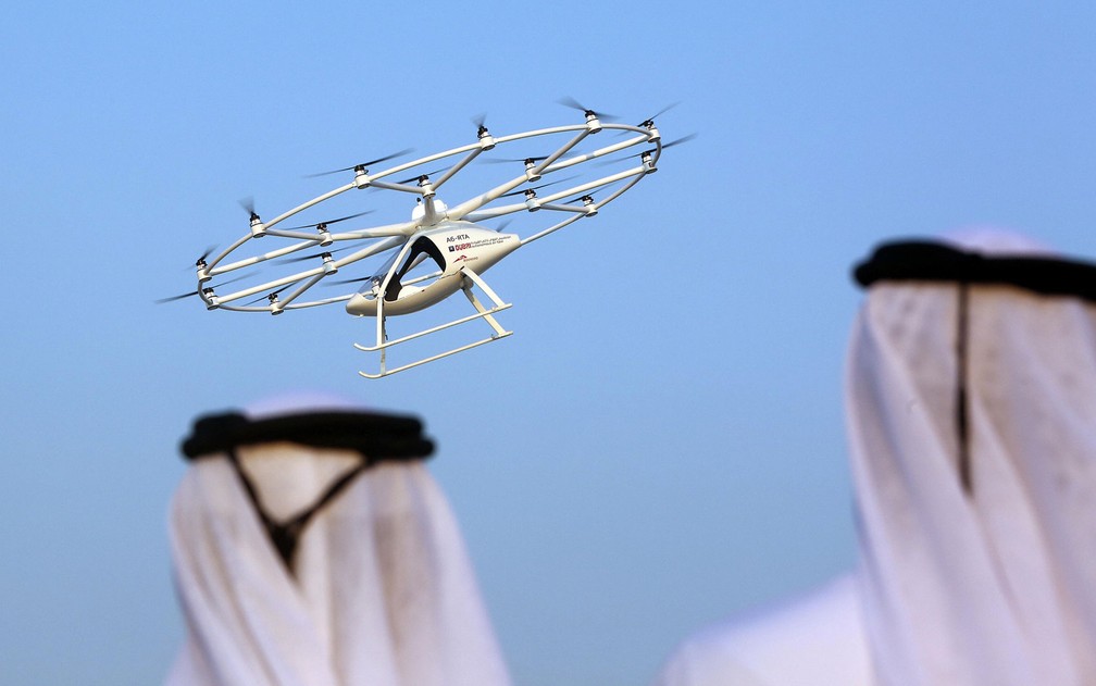 Homens observam teste de taxi-drone em Dubai, nos Emirados Árabes Unidos, na segunda-feira (25) (Foto: Reuters/Satish Kumar)