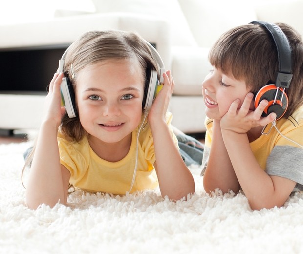 Crianças ouvindo música com fones de ouvido (Foto: Shutterstock)