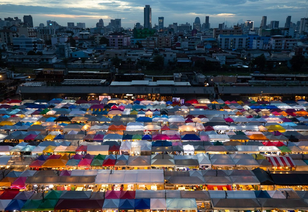 19 de junho - Barracas de comida e outros produtos são iluminadas no Rot Fai Market em Bangkok, na Tailândia, enquanto o governo continua a diminuir as restrições que foram impostas para conter a disseminação da Covid-19 no país — Foto: Sakchai Lalit/AP