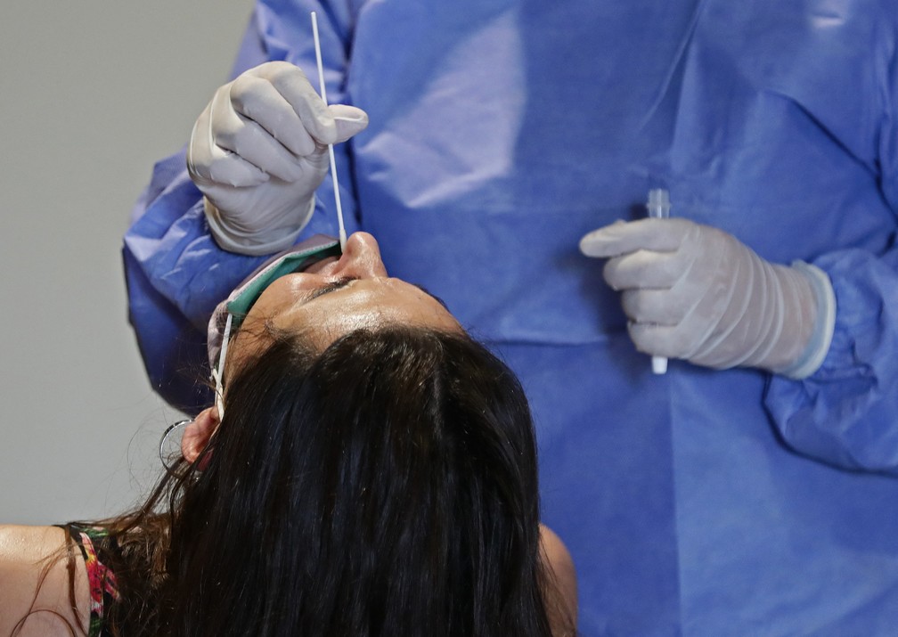 Profissional de saúde coleta amostra nasal de mulher para teste de Covid-19 em um centro de testagem gratuita em Buenos Aires, na Argentina, no dia 10 de janeiro.  — Foto: Alejandro Pagni / AFP
