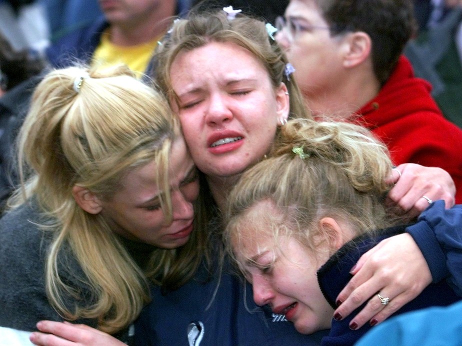 Jovens choram e se consolam durante vigília realizada pelos mortos em Columbine, em 1999, em Denver.