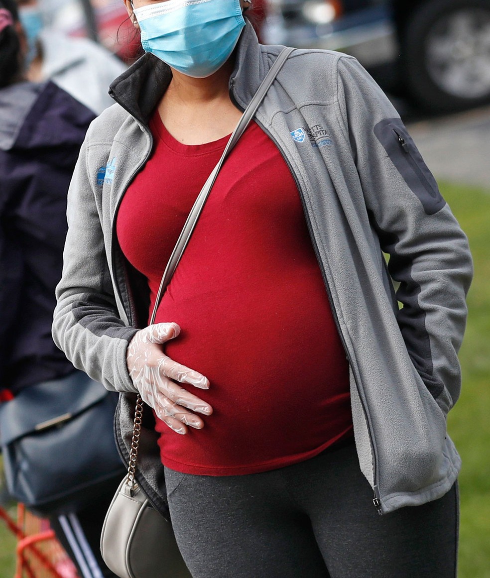 Imagem de arquivo mostra mulher grávida com máscara e luva em Waltham, Massachusetts, nos EUA  — Foto: Charles Krupa/AP 