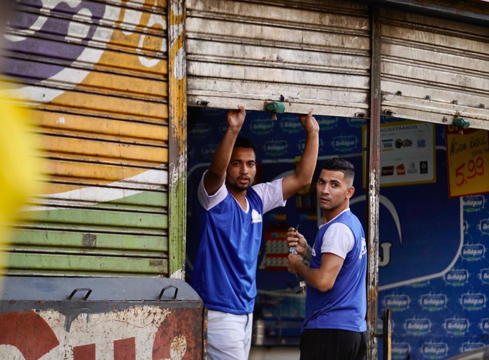 24 de março - Trabalhadores fecham as portas de um estabelecimento no Centro do Rio   — Foto: Marcos Serra Lima/ G1