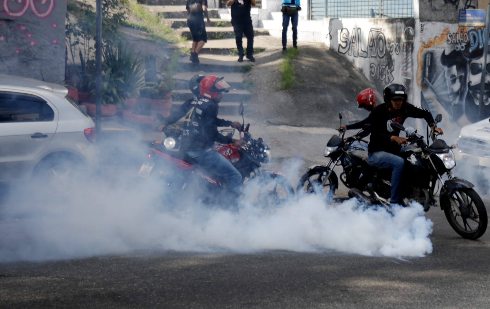 Polícia atira gás lacrimogênio contra motociclistas no Complexo do Alemão — Foto: Gabriel de Paiva / Agência O Globo