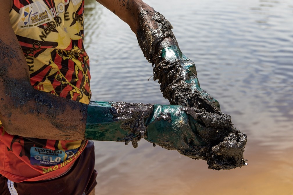 Funcionários da Prefeitura de Maragogi, no estado de Alagoas, e voluntários trabalham na retirada de óleo da praia do Peroba, nesta sexta-feira (18). — Foto: Ana Leal/O Fotográfico/Estadão Conteúdo/Arquivo