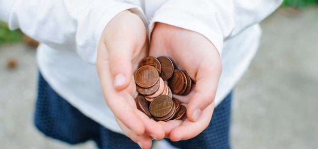 Mãos de criança segurando moedas (Foto: Shutterstock)