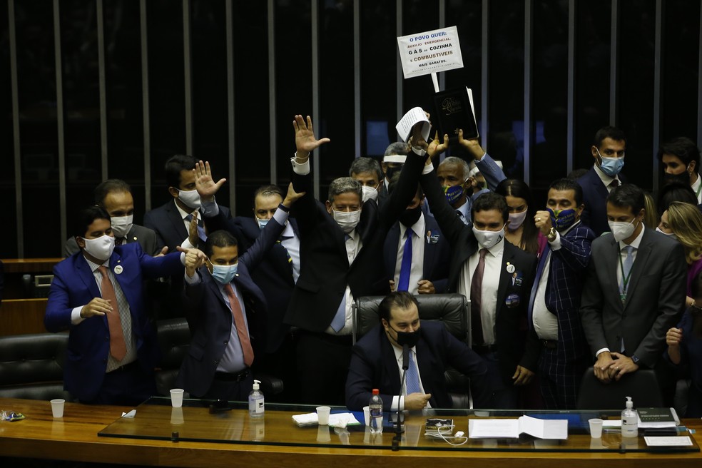  Lira, em pé, com papéis na mão, comemora a vitória antes assumir o lugar do até então presidente Rodrigo Maia (sentado), na segunda (1º) — Foto: DIDA SAMPAIO/ESTADÃO CONTEÚDO