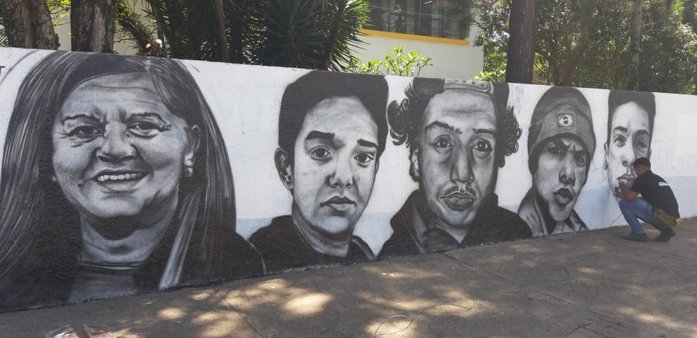 Vítimas de massacre na Raul Brasil, em Suzano, foram retratadas em preto e branco no muro da escola — Foto: Maiara Barbosa/G1
