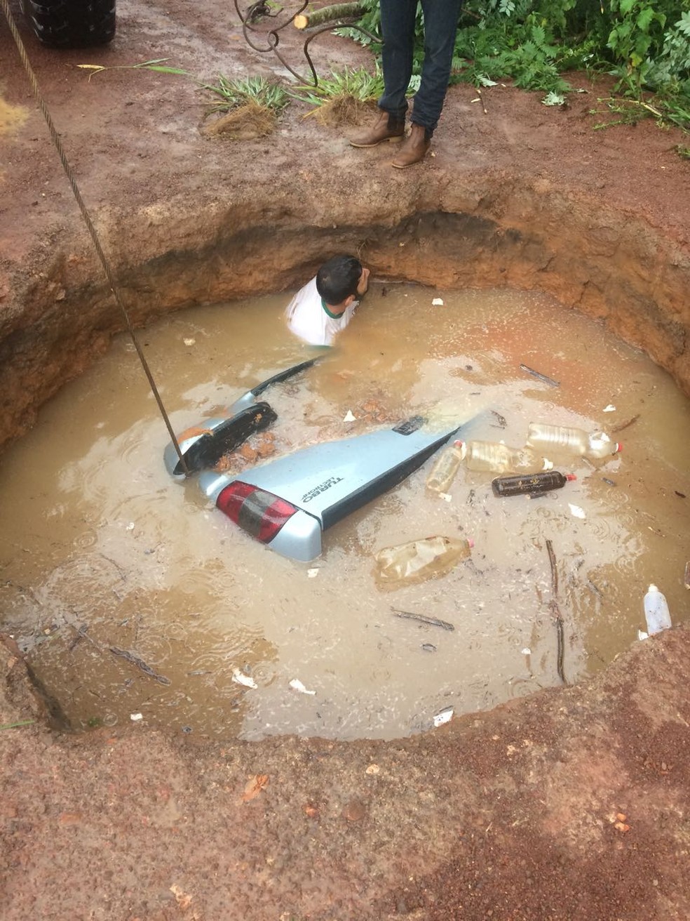 Uma pessoa teve que mergulhar na cratera para amarrar uma corda que puxaria o veículo (Foto: Arquivo pessoal)